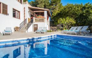 a swimming pool with chairs and a house at Corazon in Canyamel