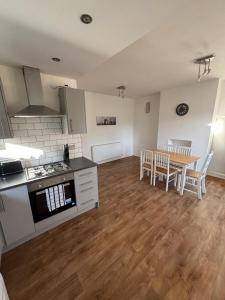 a kitchen and dining room with a table and chairs at Cosy 3 Bed house with garden 5 min walk from Doncaster Racecourse in Doncaster +8 photos