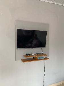 a flat screen tv on a white wall at Edilson santos in João Pessoa