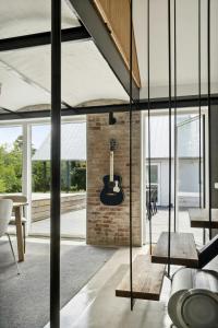 a guitar on a brick wall in a living room at Fjord-Close Cottage With Beautiful View in Hemmet +32 photos
