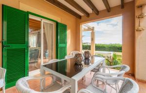 a dining room with green shutters and a table and chairs at Sa Copinya in Cala Bona
