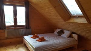 Una cama en una habitación de madera con dos ositos de peluche. en Beskidzka Chata, en Hucisko
