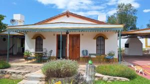 a small white house with a table and chairs at Cabañas Cerro Colonial in Trapiche