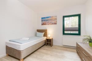 a bedroom with a bed and a window at Feriendorf Strandgut in Altenkirchen