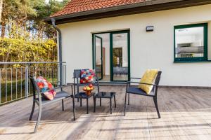 two chairs and a table on a deck at Feriendorf Strandgut in Altenkirchen +140 photos
