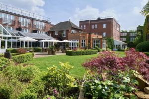 a garden in front of a large brick building at The Bull in Gerrards Cross