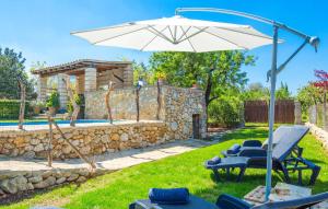 a patio with an umbrella and chairs and a pool at Perla Sort Llarga in Moscari