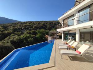 a villa with a swimming pool and some chairs at Villa Ship Ahoy in Kaş