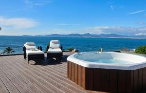 a bath tub sitting on a deck next to the ocean at Robert Christopher Börner in Badia Gran
