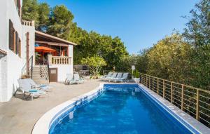 a swimming pool with chairs and a house at Corazon in Canyamel