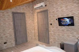 a bedroom with two doors and a tv on the wall at Gazalle Oasis in El Biar