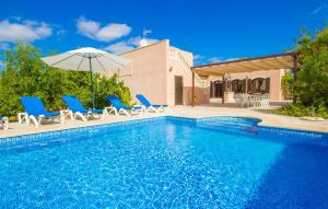 a swimming pool with blue chairs and an umbrella at Ses Comunes in Campos