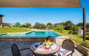 a table and chairs next to a swimming pool at S'oratge in Artá