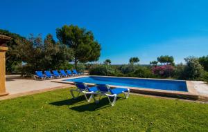 a group of chairs sitting next to a swimming pool at Can Bernat in Cala Mendia