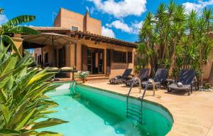 ein Pool vor einem Haus mit Palmen in der Unterkunft Es Regaro in Capdepera