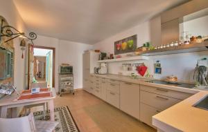 a large kitchen with white cabinets and a table at Maria Angela in Artá