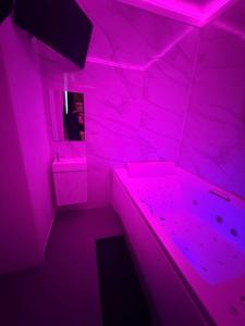 a pink room with a person in a mirror at La Suite White wellness Jacuzzi & Sauna in Seraing +2 photos