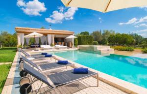 a swimming pool with chairs and an umbrella at Golf Marina in Pollença
