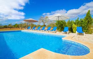 a swimming pool with blue chairs and umbrellas at Ses Comunes in Campos +44 photos