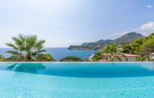 a large swimming pool with a view of the ocean at Lifetime in Font de Sa Cala