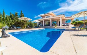 a villa with a swimming pool in front of a house at Redrema in Llucmajor