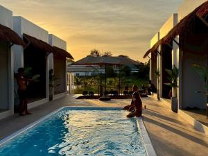 a woman sitting in a pool next to a house at The Pool House Koh Lanta in Ko Lanta