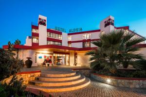 a hotel with stairs in front of a building at Hotel da Aldeia - Adults Only in Albufeira