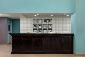 a counter in a room with pictures on the wall at Garner Hotel Murfreesboro West by IHG in Murfreesboro