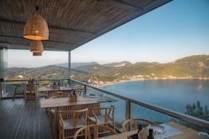 a restaurant with tables and chairs and a view of the water at PORTO TIMONI in Afionas