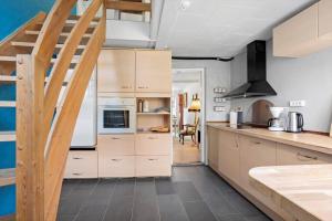 a kitchen with wooden cabinets and a spiral staircase at FY406-Faaborg-Bojestraede-4-A in Faaborg