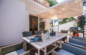 a wooden table with chairs and an umbrella on a patio at Mar Bella Nou in Font de Sa Cala
