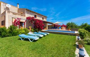 a group of lounge chairs on the grass next to a house at Etv4268, Casa Tolo in Son Servera