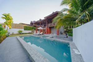 a swimming pool in front of a house at Calisto Valley I Luxury Pool Villa Krabi in Ao Nam Mao