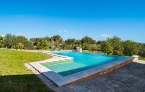 a swimming pool in a yard with a grass field at S'oratge in Artá