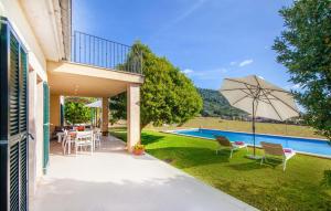 a patio with a table and an umbrella next to a pool at Sa Mina De Crestatx in Sa Pobla