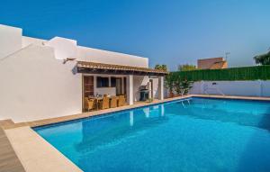 a swimming pool in front of a villa at Murta 26 in Sa Coma