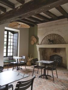 a room with tables and chairs and a fireplace at Manoir Du Moulinet in Château-Gontier
