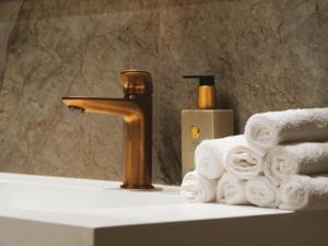 a bathroom sink with a faucet and a pile of towels at Manoir Du Moulinet in Château-Gontier +24 photos