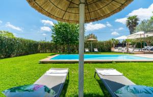 two chairs under an umbrella next to a swimming pool at Es Collet De Manacor in Manacor