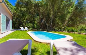 a swimming pool in a yard with two chairs at Na Mikeleta in Capdepera