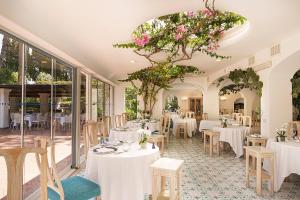 a restaurant with white tables and chairs and flowers at Grand Hotel Il Moresco in Ischia Town