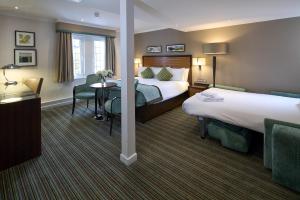 a hotel room with two beds and a table at The Bull in Gerrards Cross +33 photos
