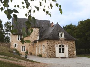 an old stone house with a black roof at Manoir Du Moulinet in Château-Gontier