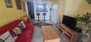 a living room with a red couch and a flat screen tv at Cozy & Zen in Saint-Denis