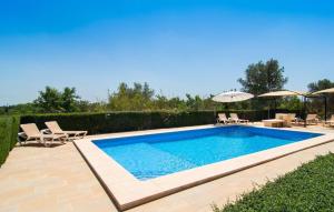 Ein Swimmingpool im Garten mit Stühlen und einem Sonnenschirm in der Unterkunft Ceratonia in Binissalem