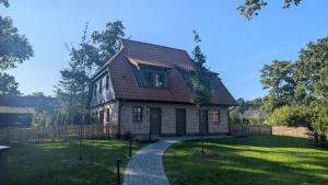 a house with a pathway in front of a yard at Ferienhaus Ovis Natur, Ruhe und Erholung in der Lüneburger Heide, Hunde willkommen in Winsen