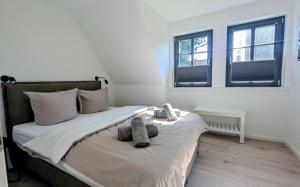 a bedroom with a bed with two stuffed animals on it at Ferienhaus Ovis Natur, Ruhe und Erholung in der Lüneburger Heide, Hunde willkommen in Winsen +11 photos