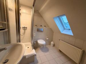 a bathroom with a sink toilet and a window at Gasthof Hotel Bräustübl und Haus Boutique in Selb