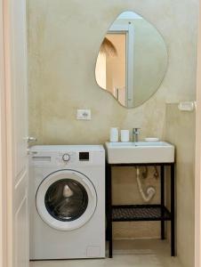 a bathroom with a washing machine and a sink at SĀN Living in Golem
