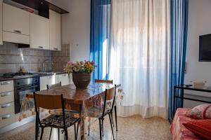 a kitchen with a table with a vase of flowers on it at Cav Costa degli Etruschi in San Vincenzo